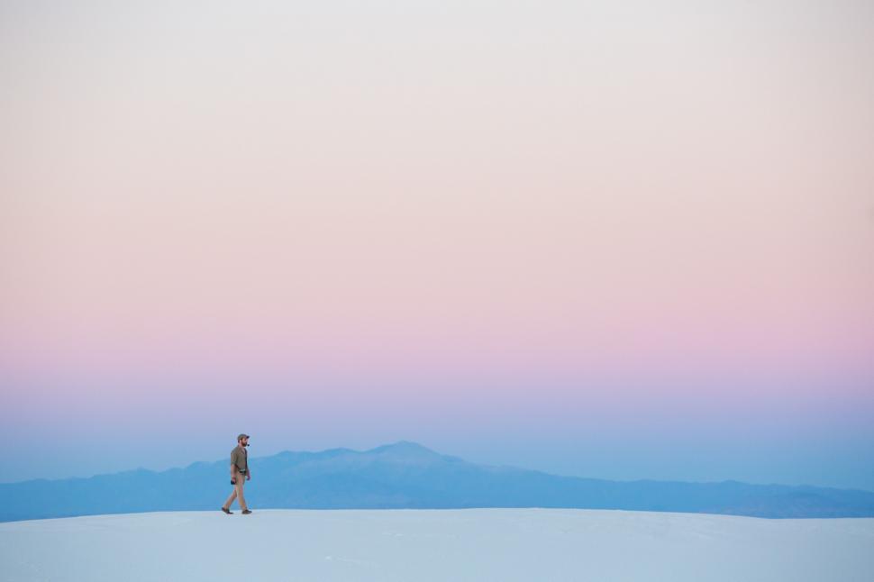 Free Image of Person Walking Across Snow Covered Field 