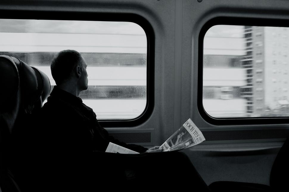 Free Image of Man Sitting on Train, Looking Out Window 