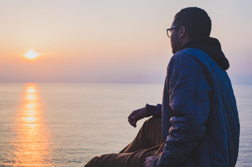 Free Image of Man Sitting on Bench Overlooking Ocean 