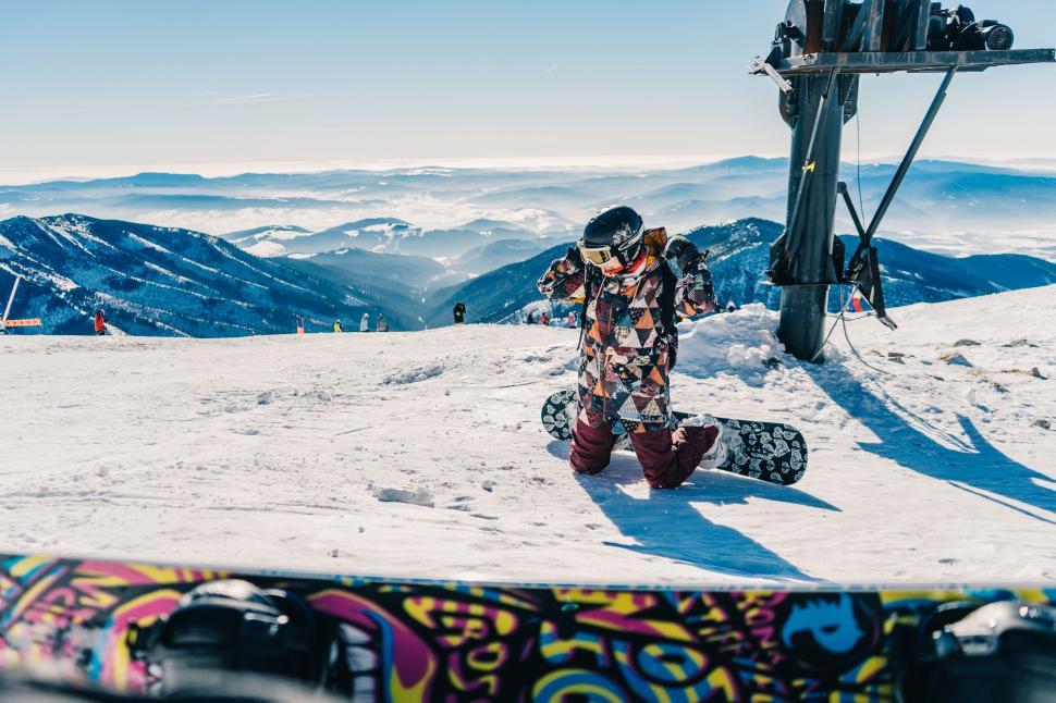 Free Image of Snowboarder Standing Atop Mountain Peak 