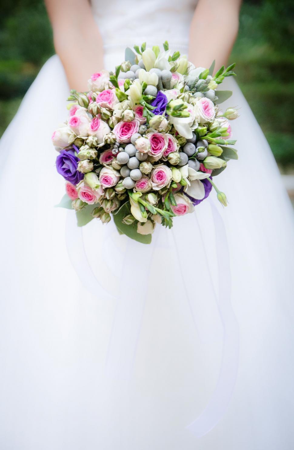 Free Image of Bride Holding Bouquet of Flowers 