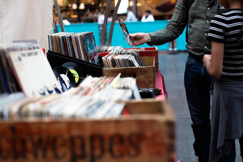 Free Image of Man and Woman Standing Next to Table Full of Records 