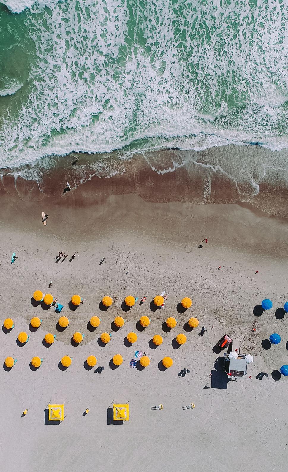 Free Image of Aerial View of Beach With Umbrellas and Chairs 