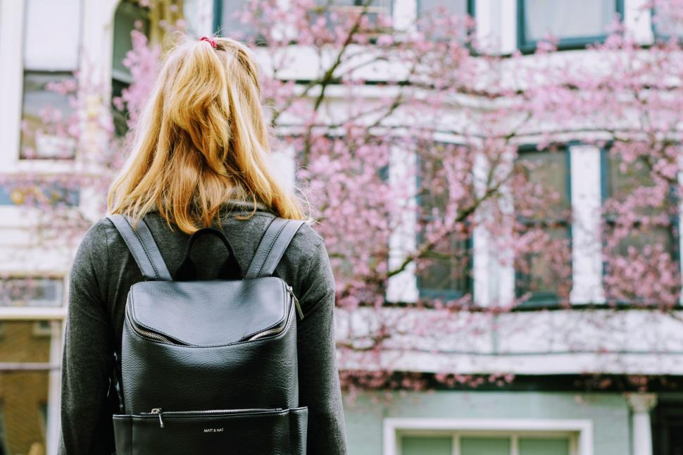 Free Image of Woman Walking Down the Street With Backpack 