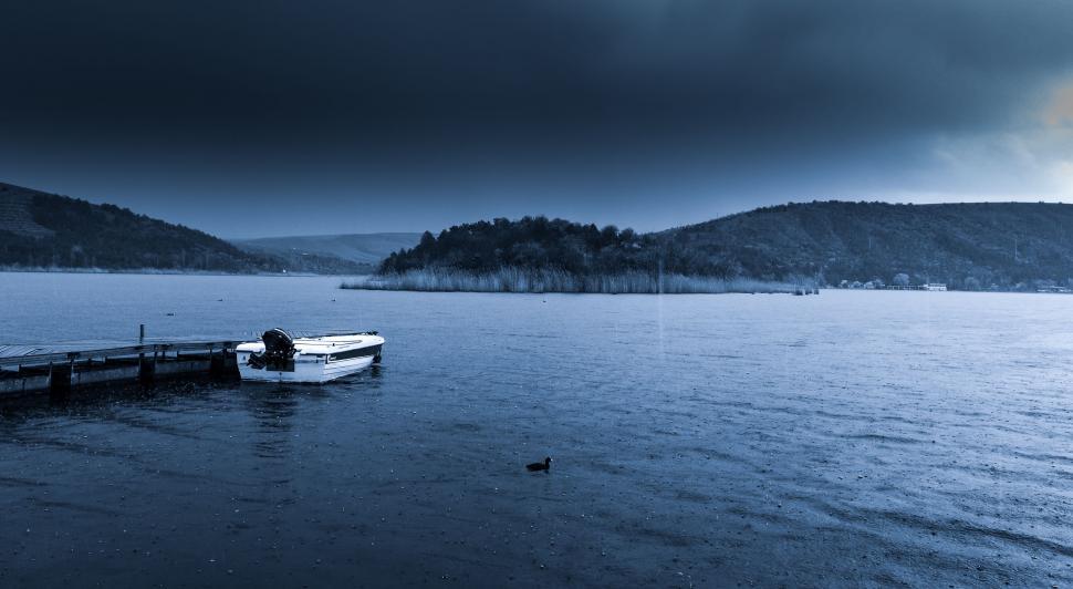 Free Image of Boat Floating on Lake Under Cloudy Sky 