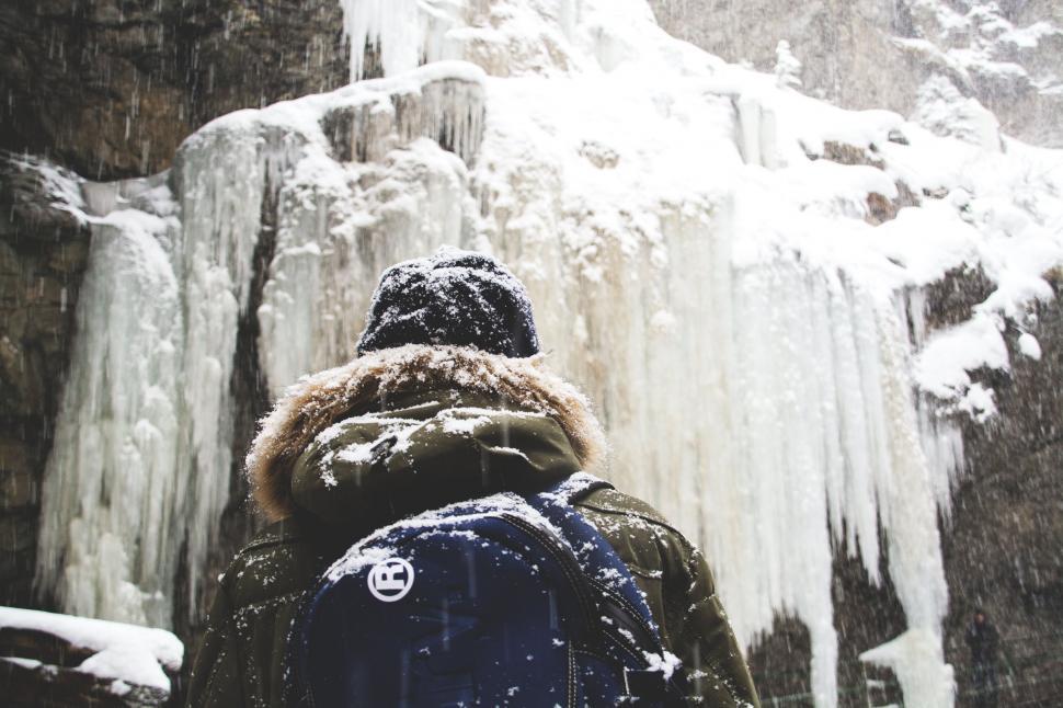 Free Image of Person Standing in Front of Frozen Waterfall 