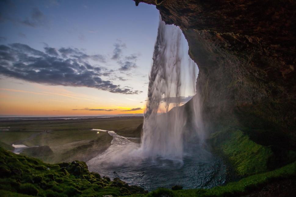 Free Image of Majestic Waterfall Flowing Out of Cave 