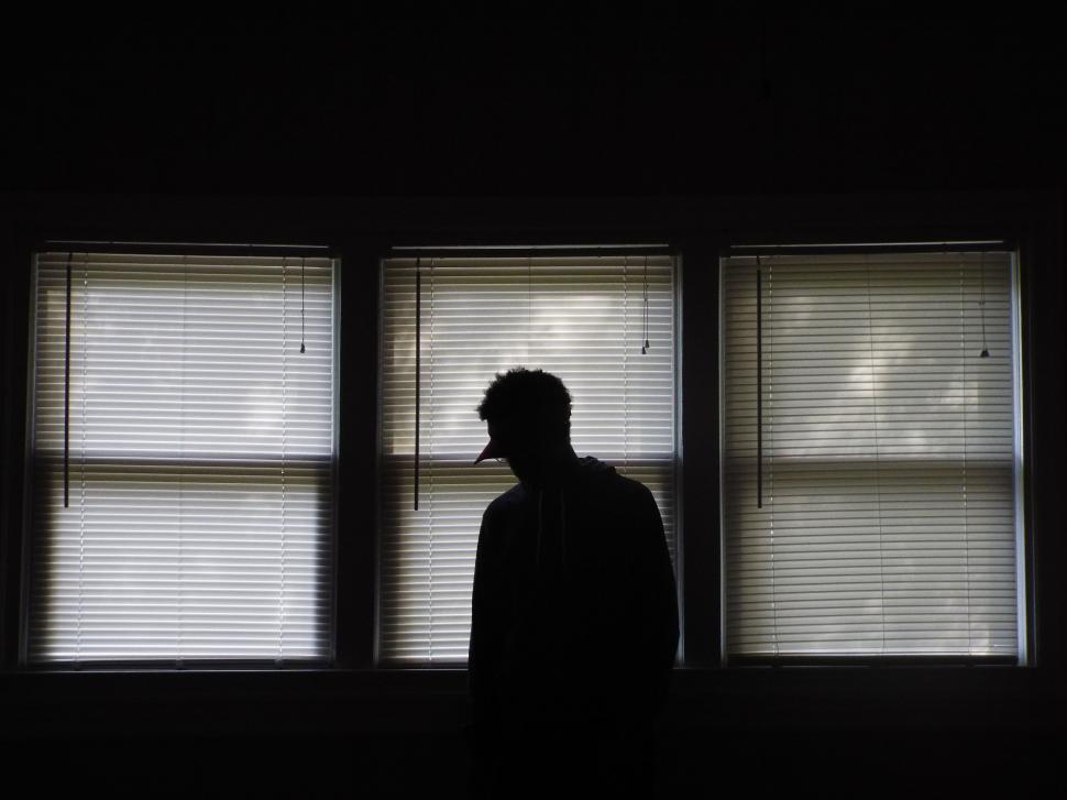 Free Image of Man Standing in Front of Three Windows 
