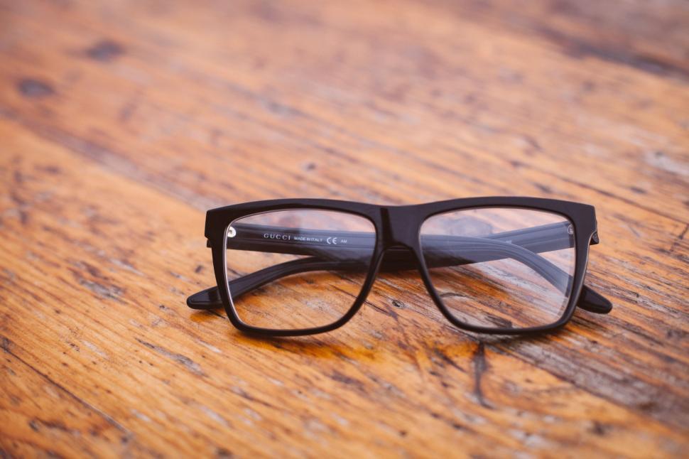 Free Image of A Pair of Glasses on Wooden Table 