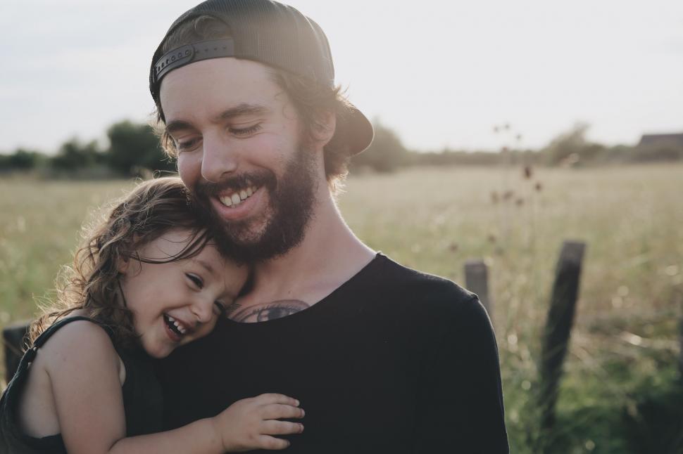 Free Image of Man Holding Little Girl in Field 