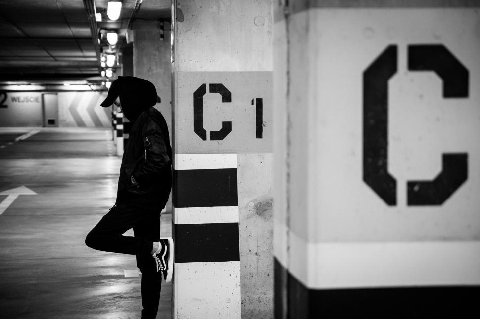 Free Image of Person Standing in Parking Garage Next to Pole 