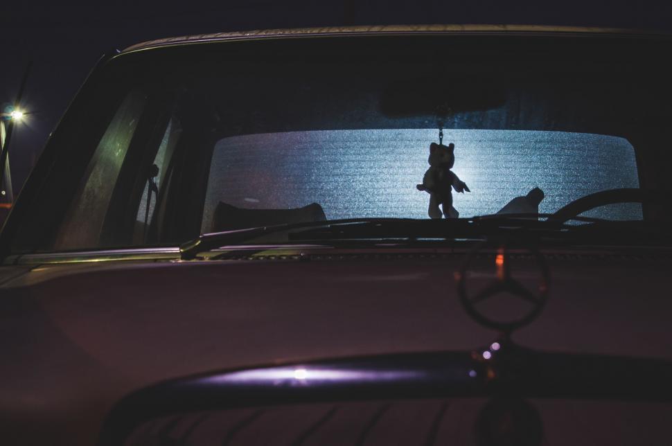 Free Image of Silhouette of Teddy Bear on Car Hood 