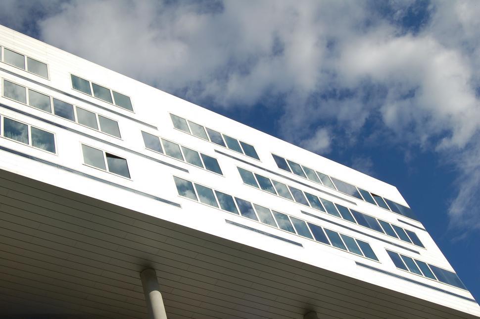 Free Image of Tall White Building Under Cloudy Blue Sky 