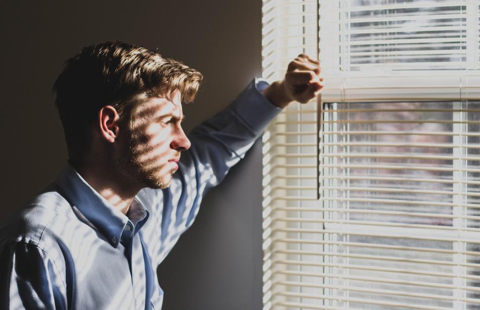Free Image of Man Looking Out of Window 