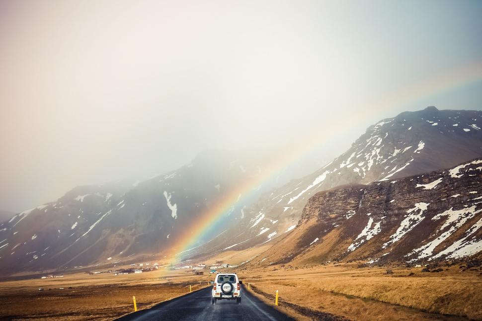 Free Image of Truck Driving Down Road With Rainbow in Background 