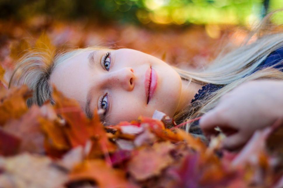 Free Image of Woman Laying in a Pile of Leaves 