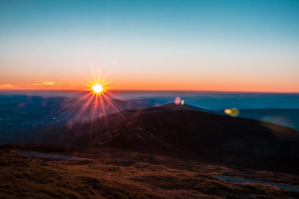 Free Image of The Sun Setting Over a Mountain Range 
