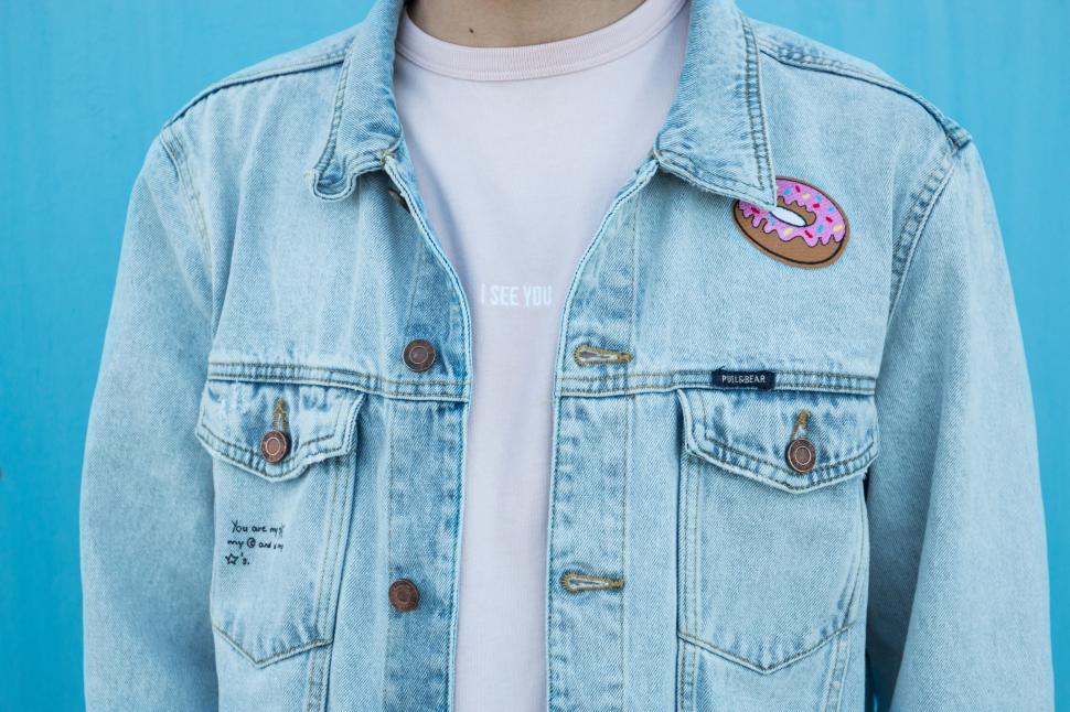 Free Image of Person Wearing Denim Jacket With Donut Design 