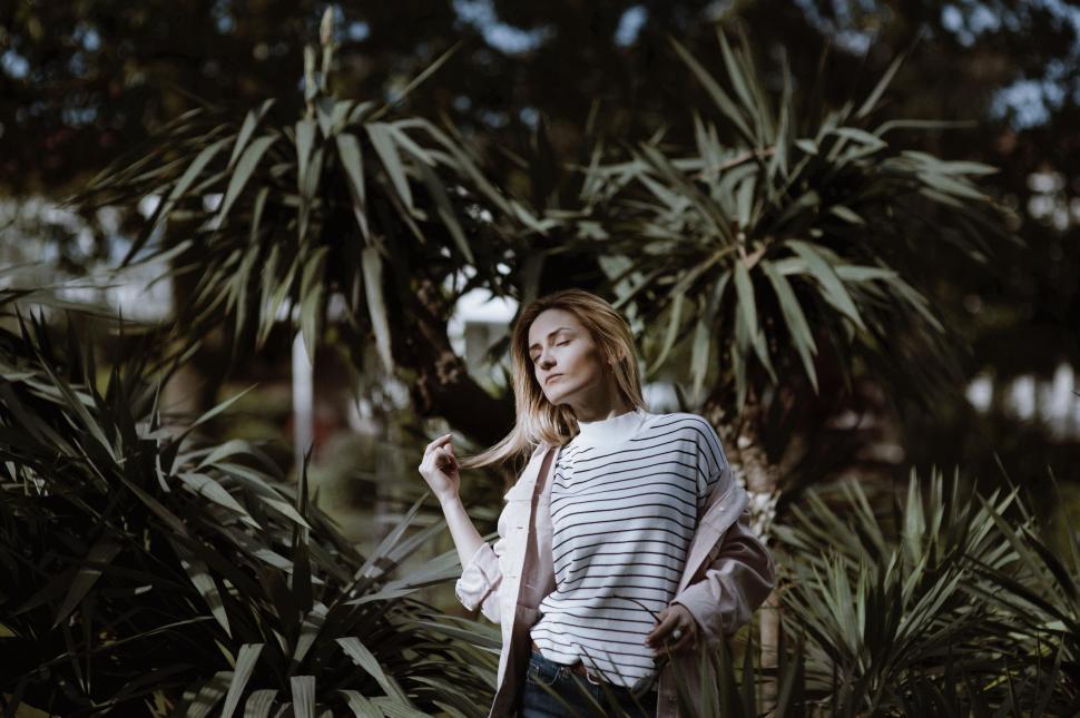 Free Image of Woman in Striped Shirt Standing in Forest 