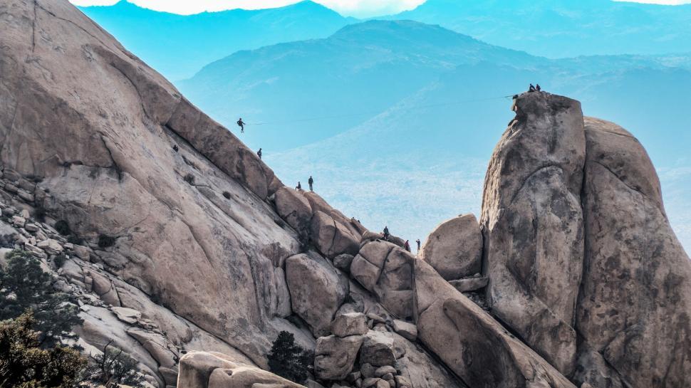Free Image of Group of People Standing on Top of a Mountain 