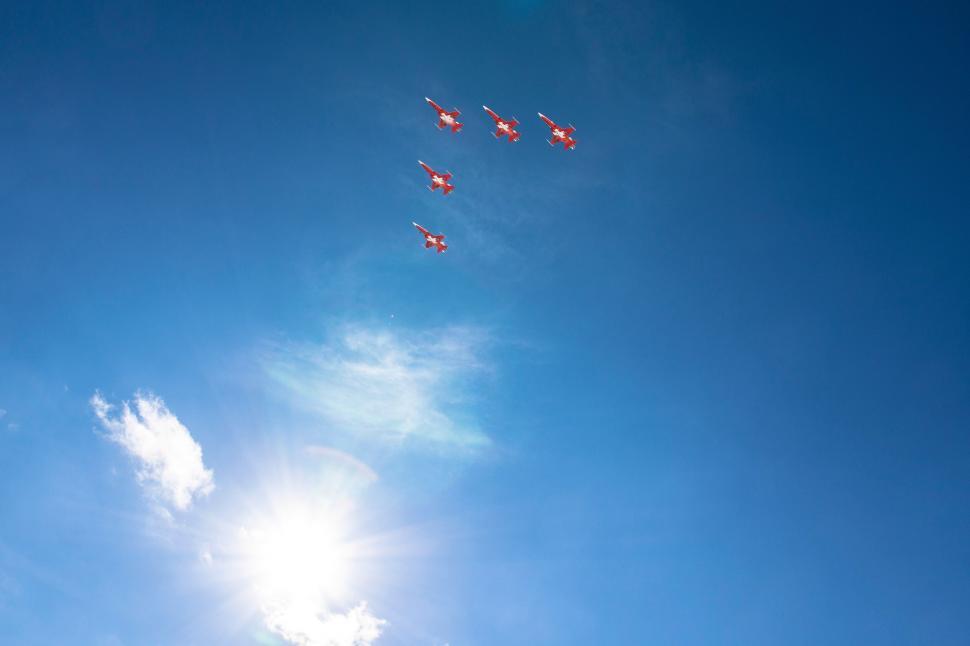 Free Image of Group of Red Kites Flying Through Blue Sky 