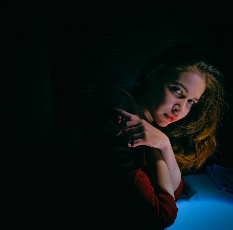 Free Image of Woman Holding Cell Phone in Dark Room 