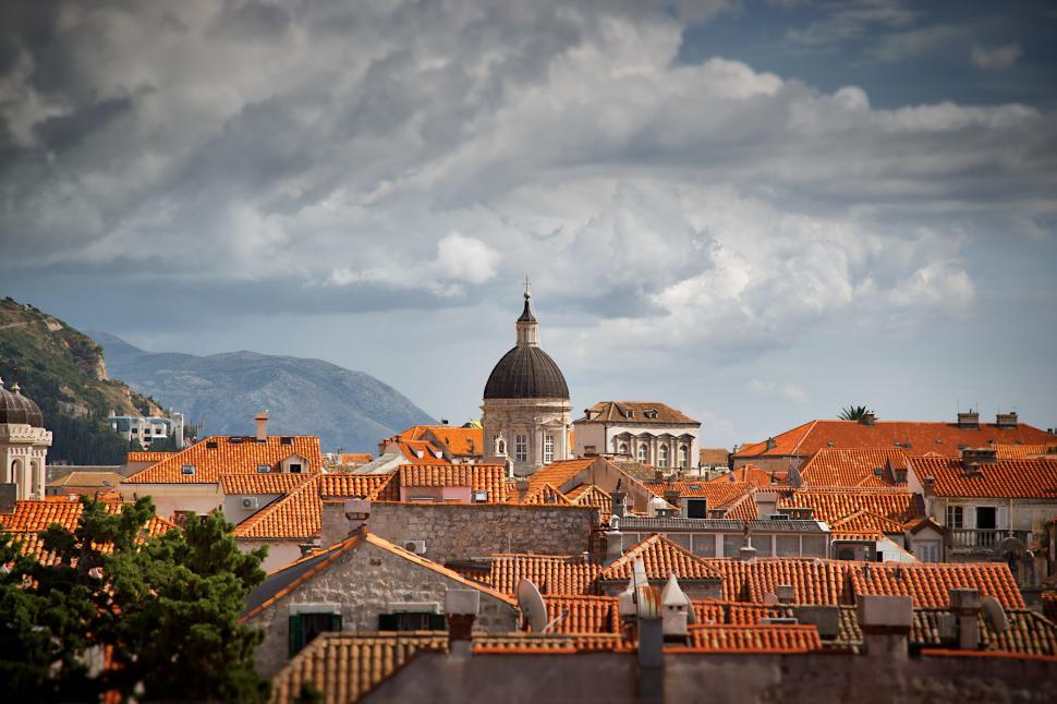 Free Image of Cityscape With Orange Roofs and Mountains 