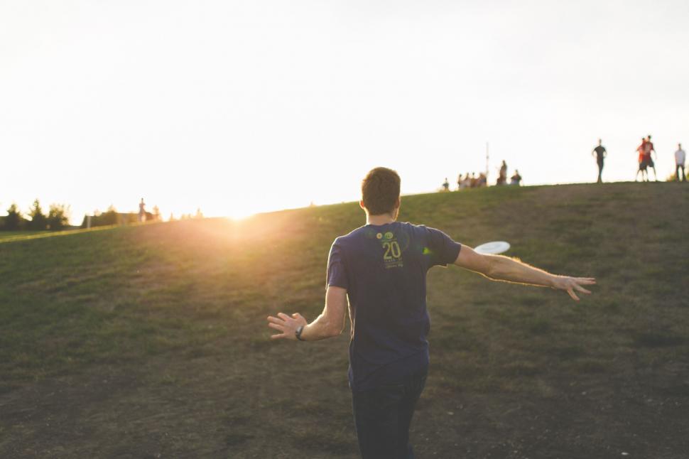 Free Image of Man Throwing Frisbee on Hill 