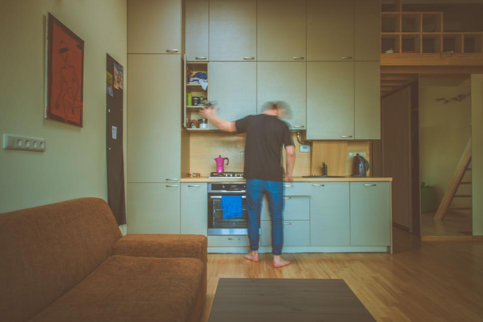 Free Image of Man Standing in Kitchen Next to Couch 
