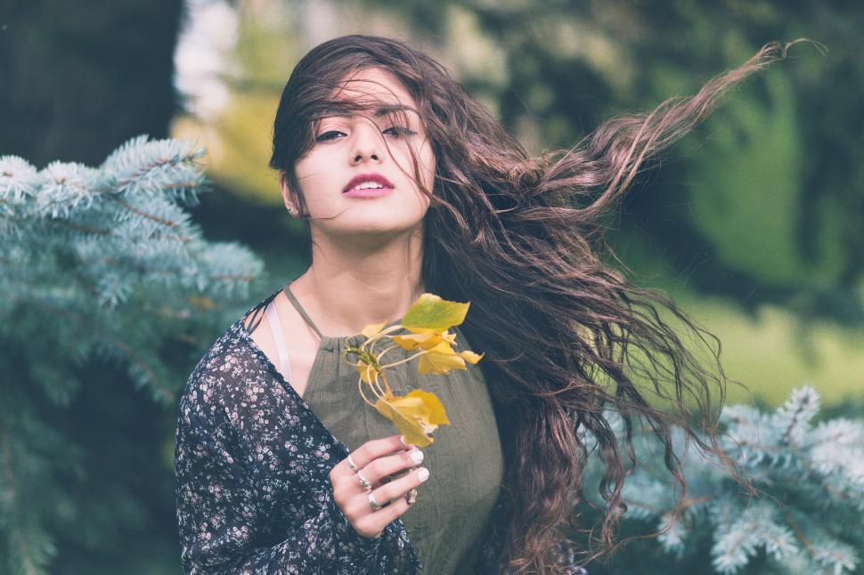 Free Image of Woman Holding Flower in Long Hair 
