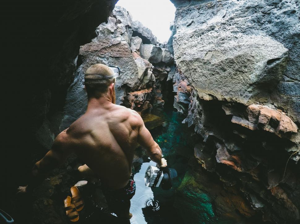 Free Image of Man Standing in Cave Next to Water 