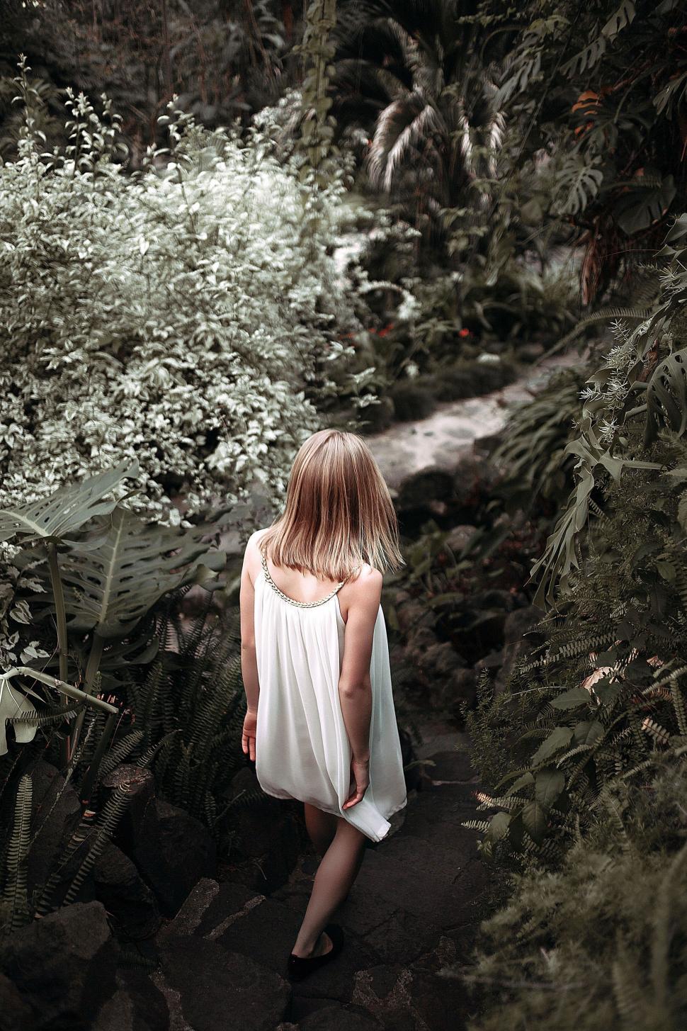 Free Image of Woman in White Dress Walking Through Forest 