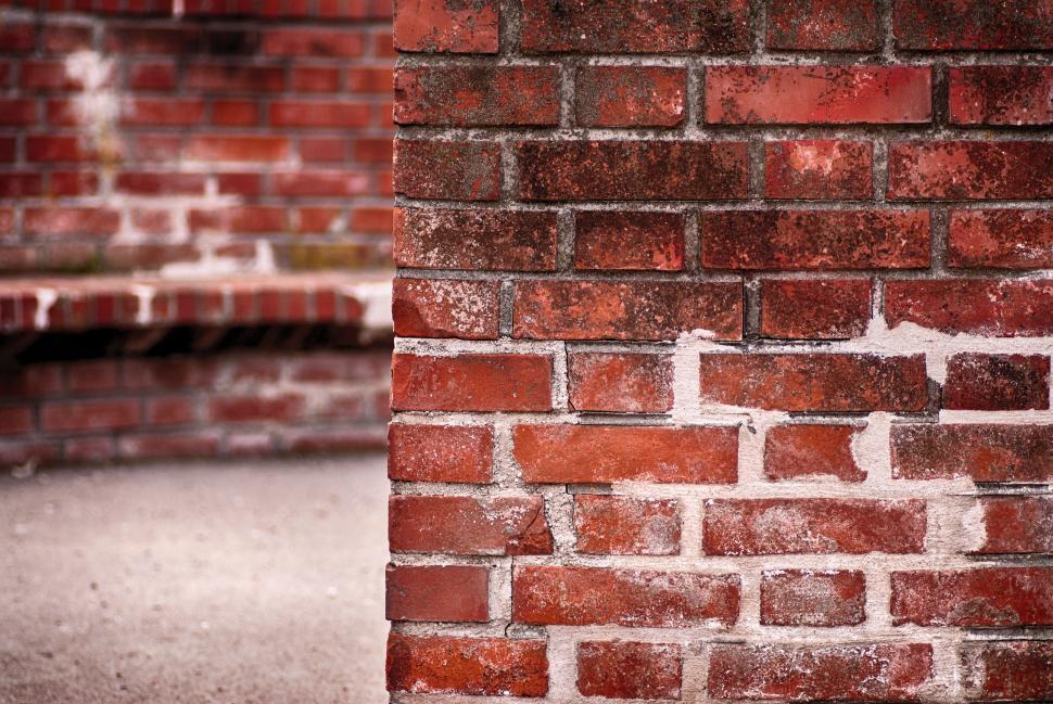 Free Image of Close Up of Brick Wall With Bench in Background 