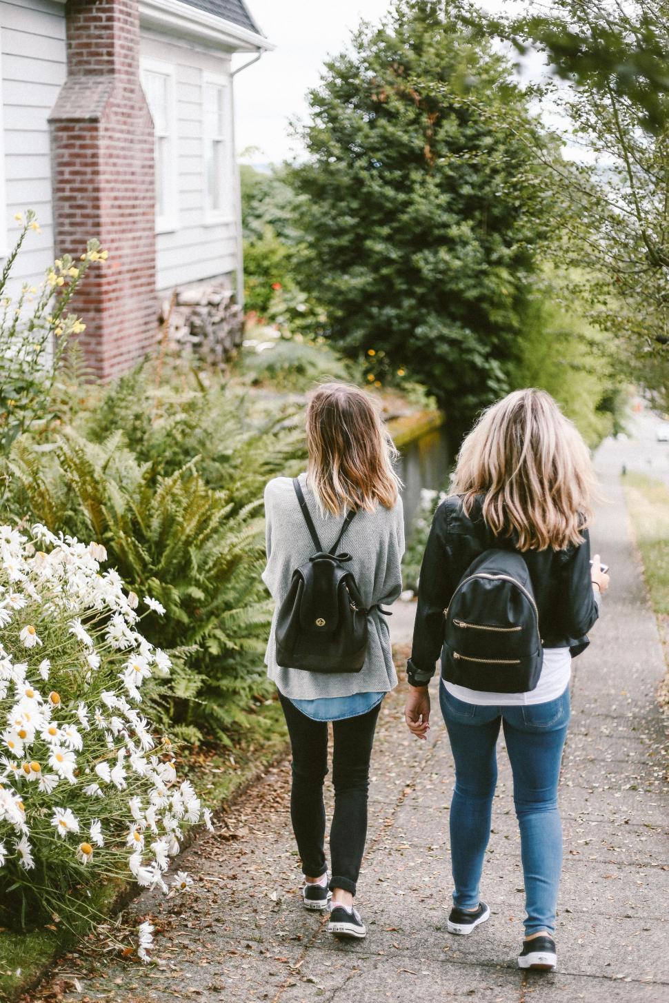 Free Image of Two Girls Walking Down a Path Holding Hands 