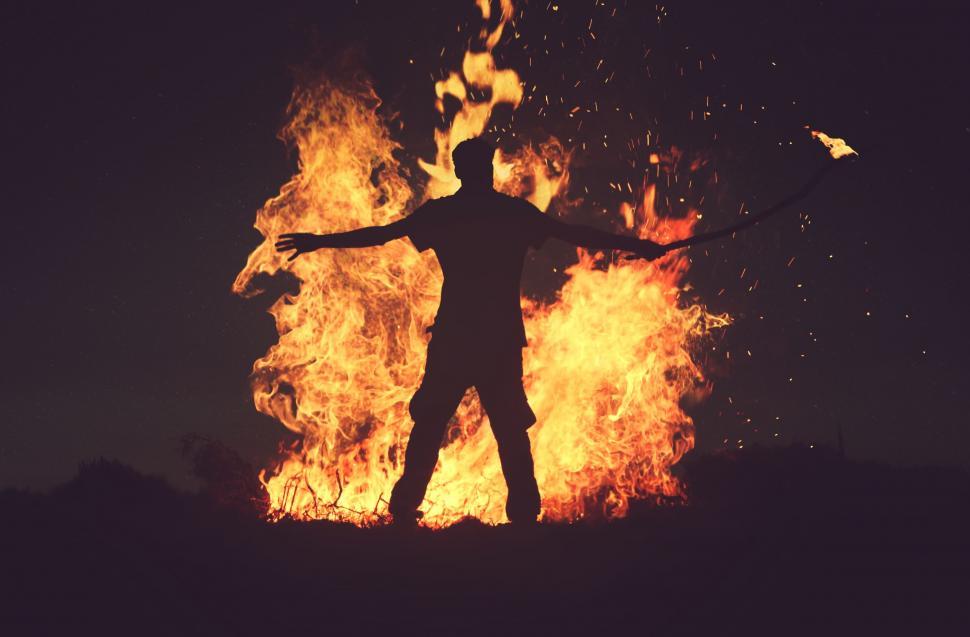 Free Image of Man Standing in Front of Large Fire 