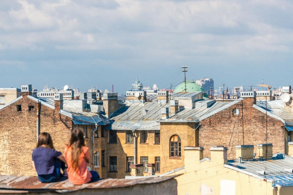 Free Image of Couple Sitting on Top of a Roof 