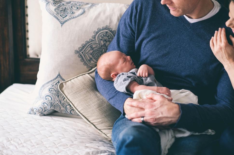 Free Image of Man Holding Baby on Bed 