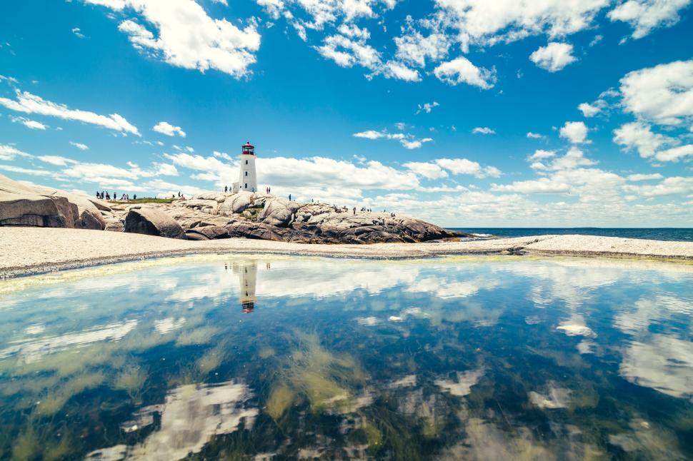 Free Image of Lighthouse Overlooking Expansive Body of Water 
