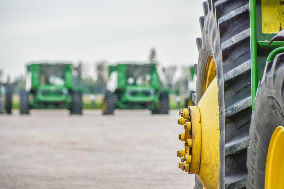 Free Image of Close Up of Tractor Tire With Background of Other Tractors 