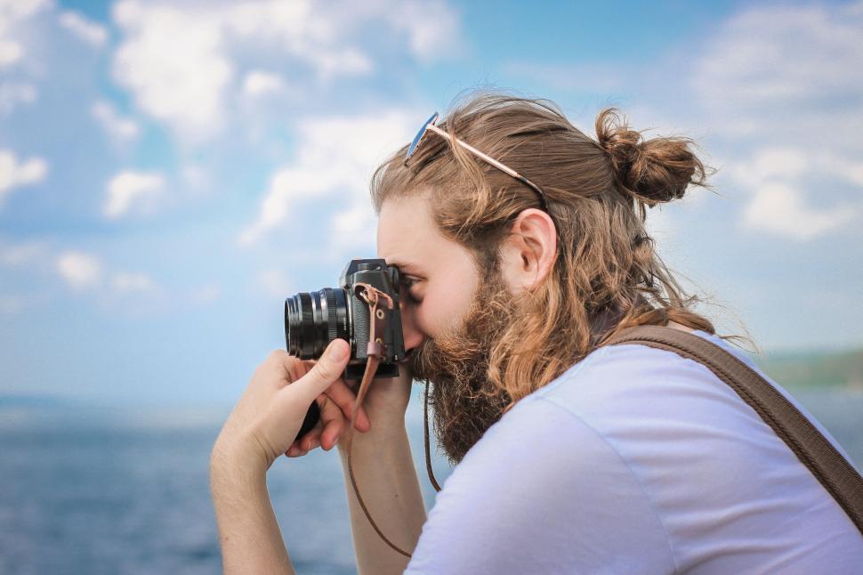 Free Image of Woman Taking a Picture of the Ocean With a Camera 