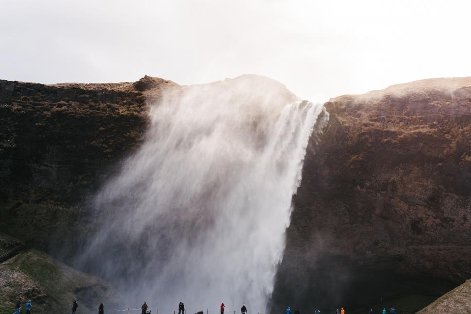 Free Image of Group of People Standing in Front of Waterfall 