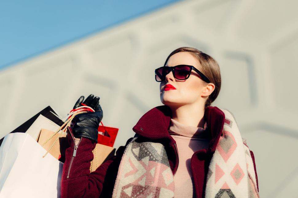Free Image of Woman Holding Shopping Bags and Cell Phone 