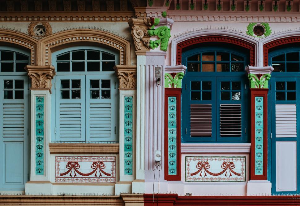 Free Image of Multicolored Building With Blue and Red Shutters 