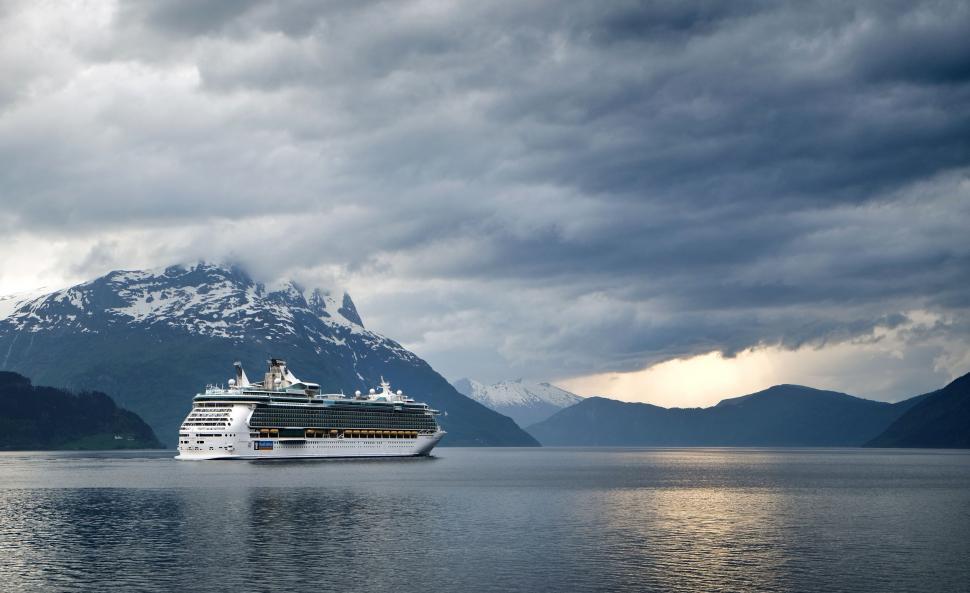 Free Image of Cruise Ship Sailing in Water With Mountains 
