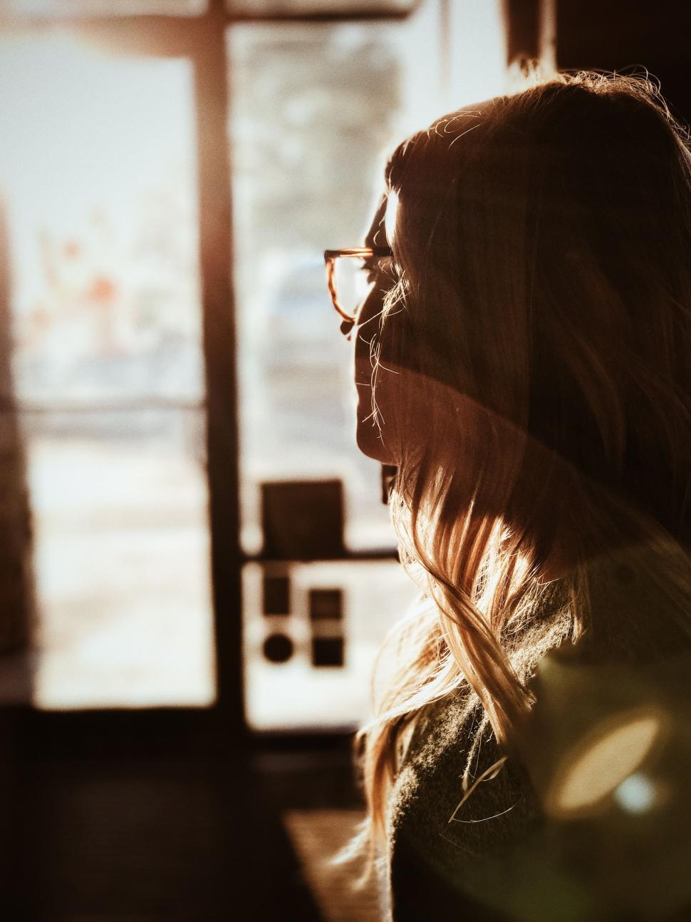 Free Image of Woman Standing in Front of Window 