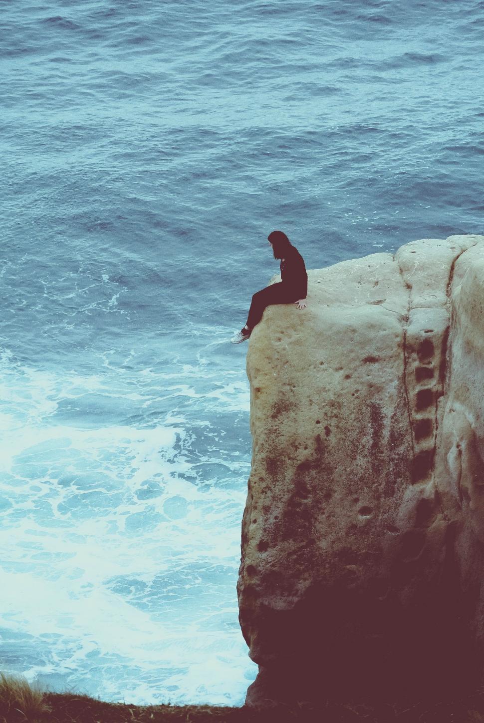 Free Image of Person Sitting on Rock by Ocean 