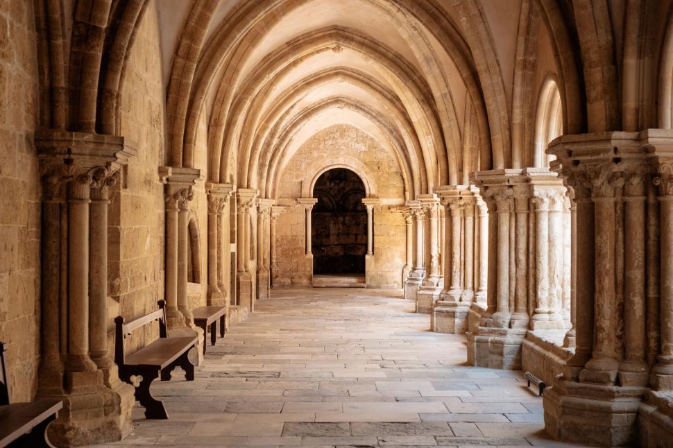 Free Image of Long Hallway With Stone Arches and Benches 