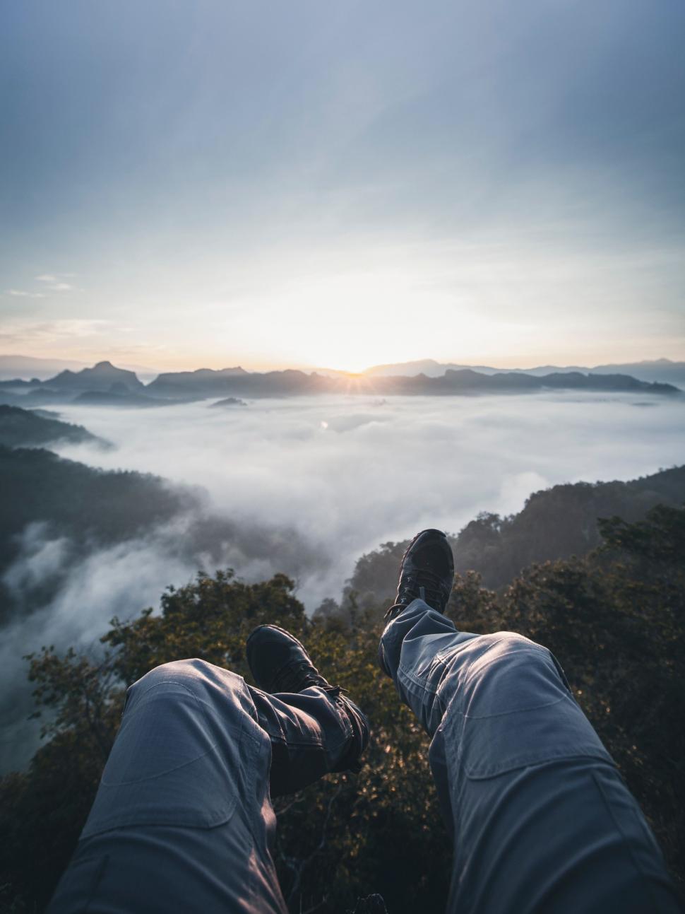 Free Image of Person Standing on Mountain Top With Feet Raised 