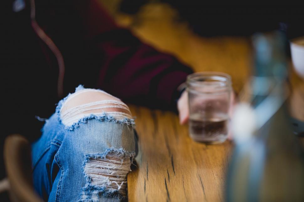 Free Image of Ripped Jeans on Wooden Table 