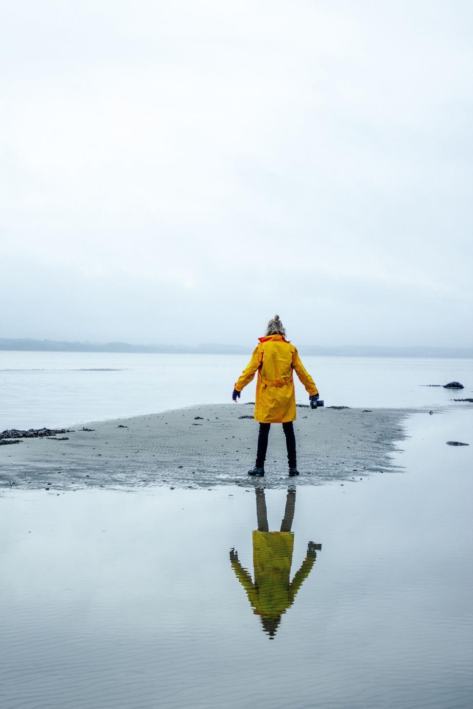 Free Image of Person in Yellow Jacket Standing on Beach 